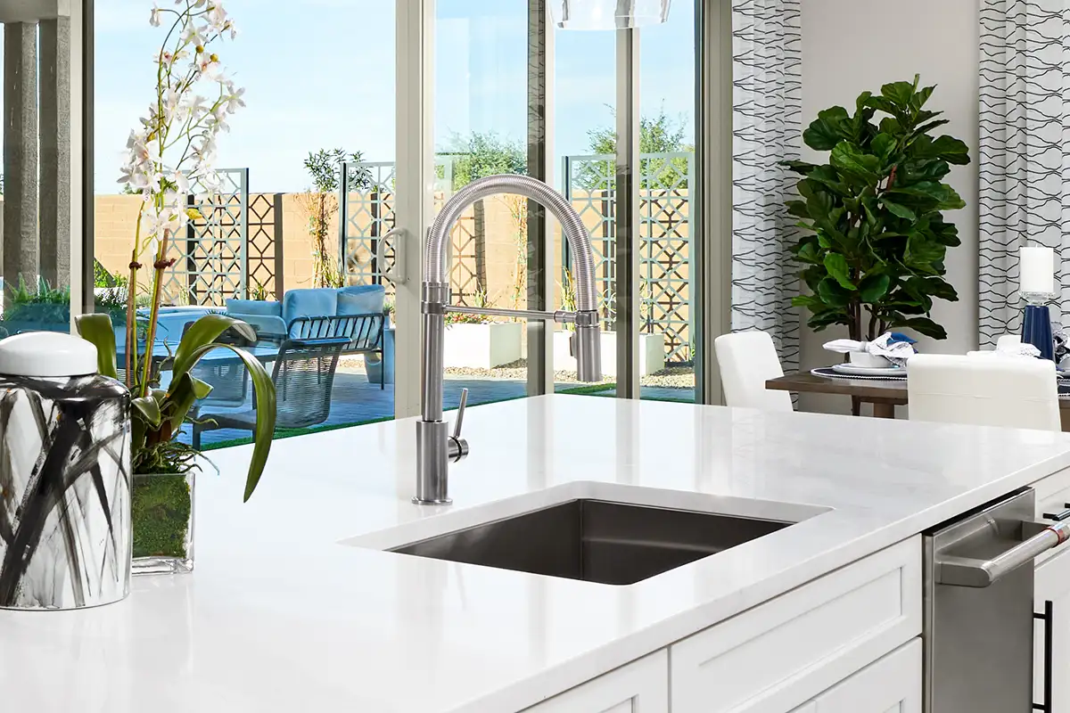 Portfolio collection detail of kitchen with white countertops, white cabinets with stainless steel faucet