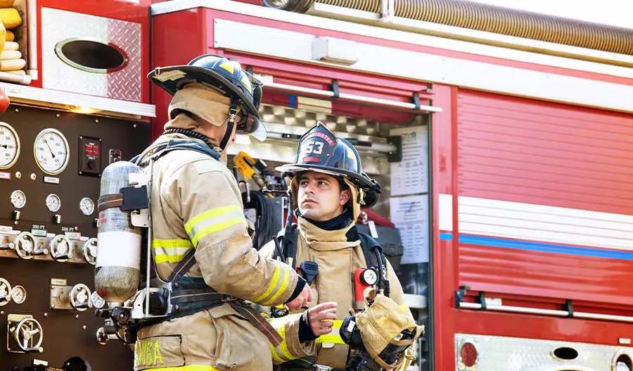 firefighters talking aside a fire engine
