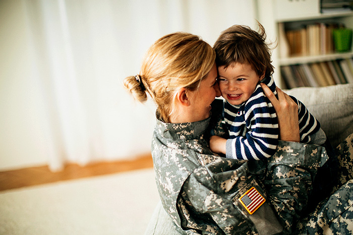 Military woman hugging her child