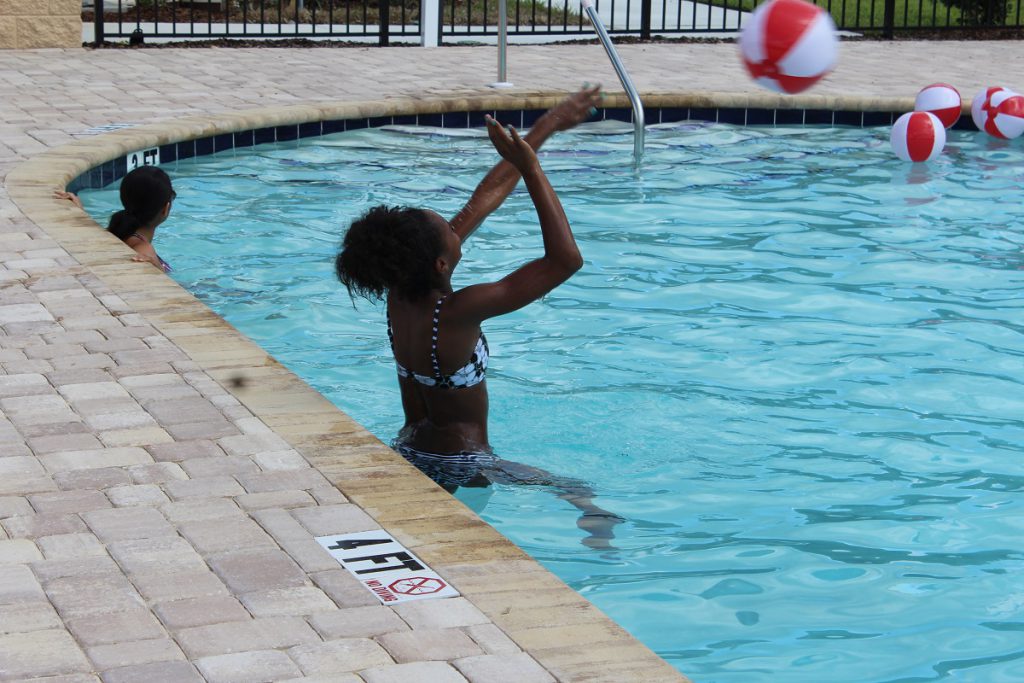 People enjoying community swimming pool at a recent Open House in Florida