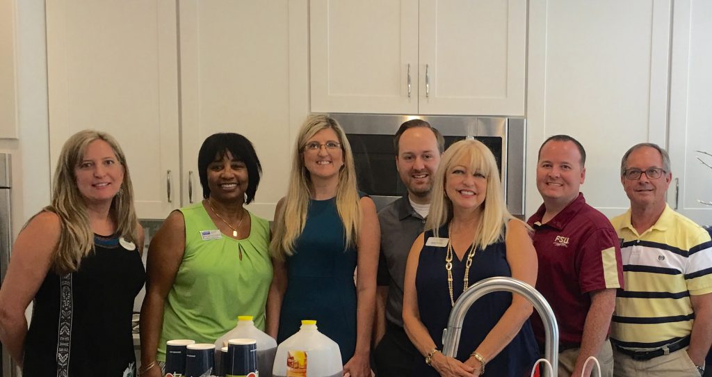 Real estate agents standing in model home kitchen during an agent appreciation lunch