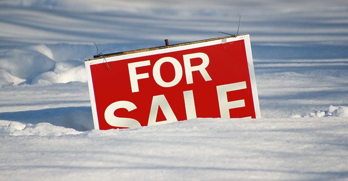 For sale sign, half buried in snow