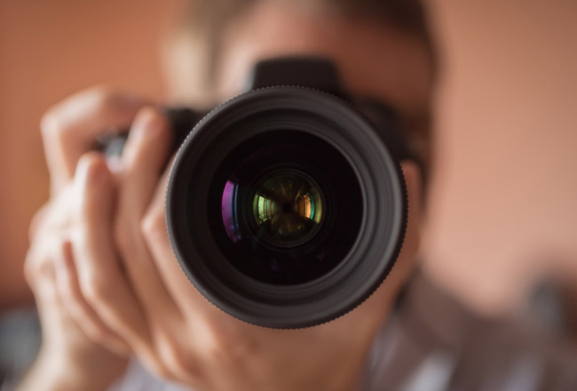 Man looking through camera lens