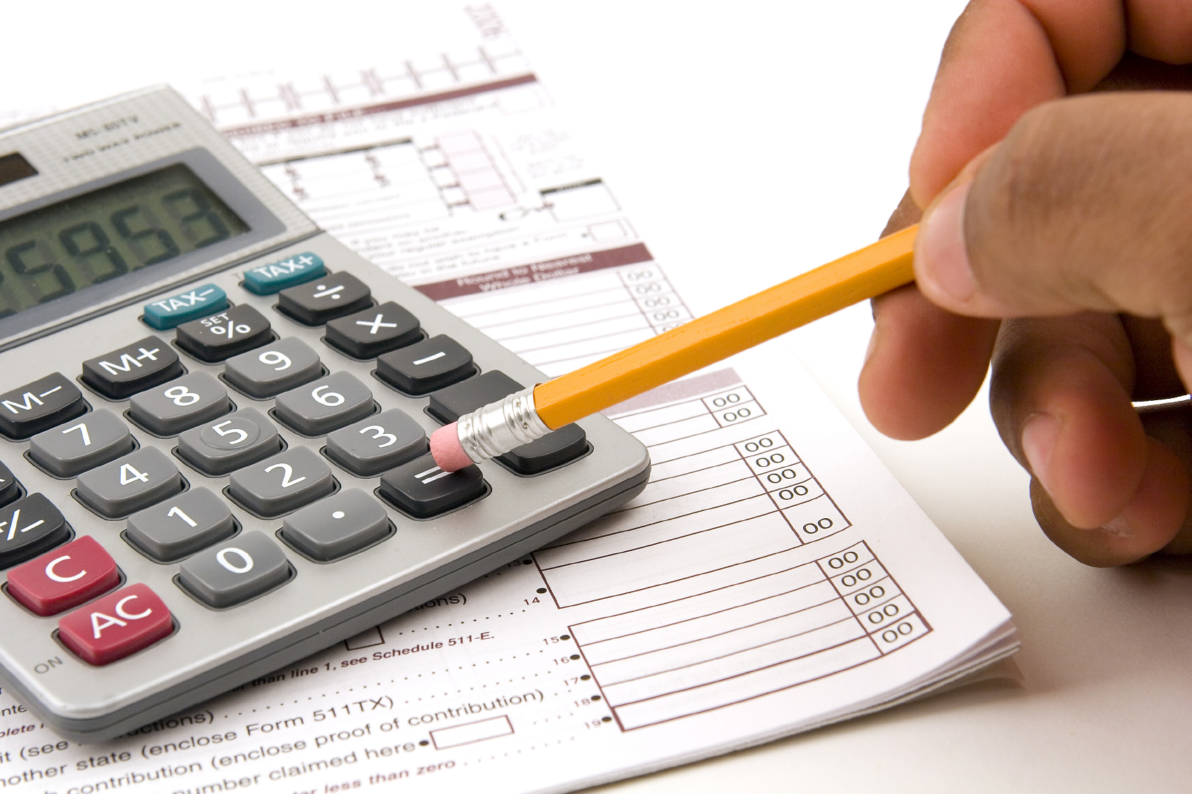 Hand using pencil to operate calculator