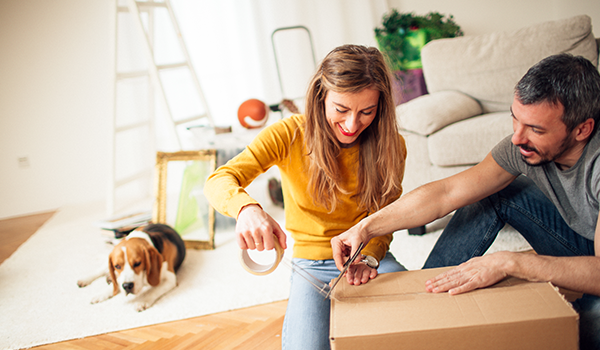 Couple taping up moving box