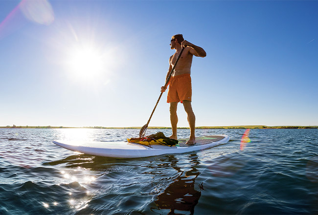 Man stand up paddleboarding on Aurora Reservoir