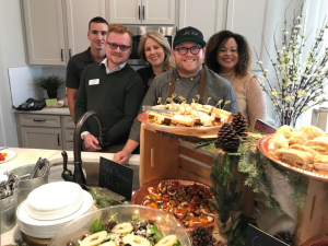 People gathered around food displayed on kitchen island