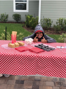 Child sitting at picnic table in backyard