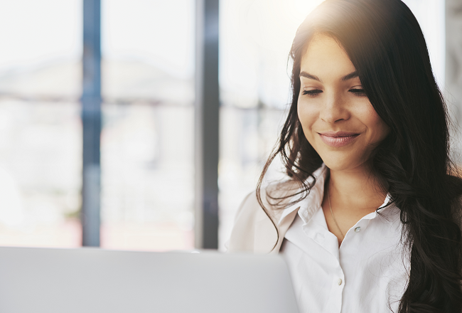 Woman smiling at computer screen