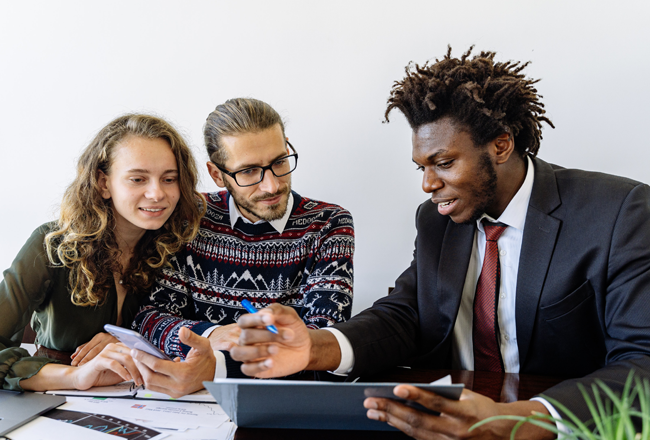 Couple meeting with loan officer to sign paperwork