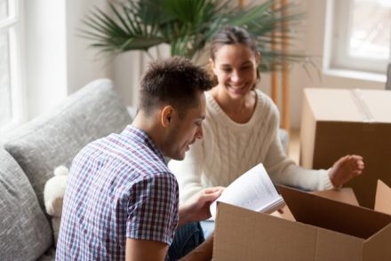 Couple sitting on sofa in front of moving box