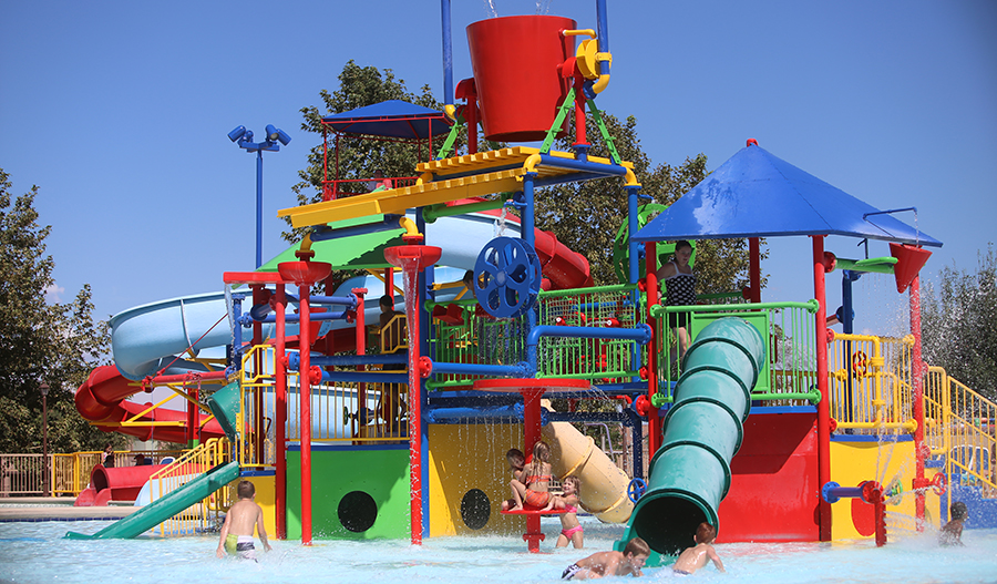 Colorful splash park equipment with kids playing in the water