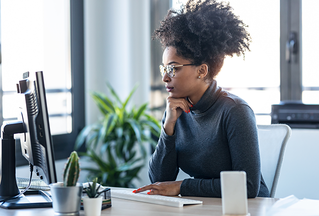 Woman at desk looking at computer screen