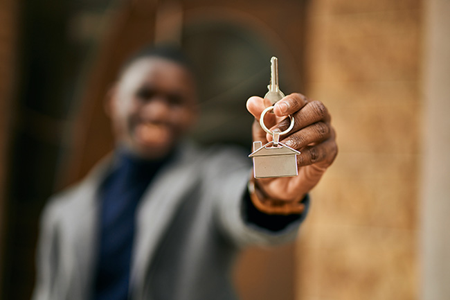 Man holding out a house key