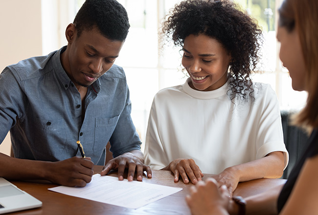 Man and woman signing new home paperwork