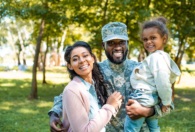 Military man smiling with wife and child