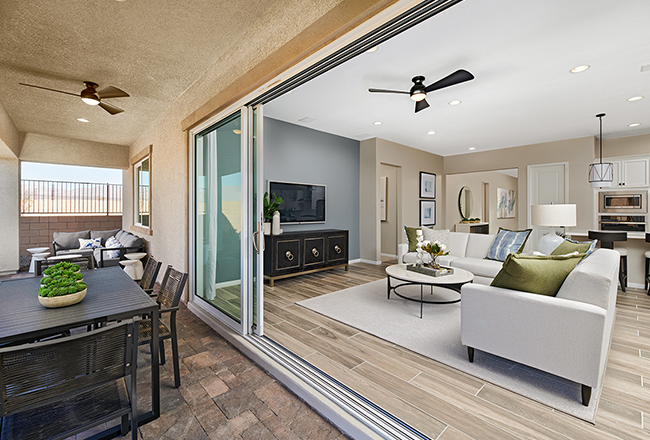 Great room with multi-slide doors opening onto covered patio with dining table