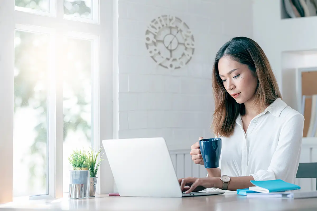 Woman at computer with coffee cup