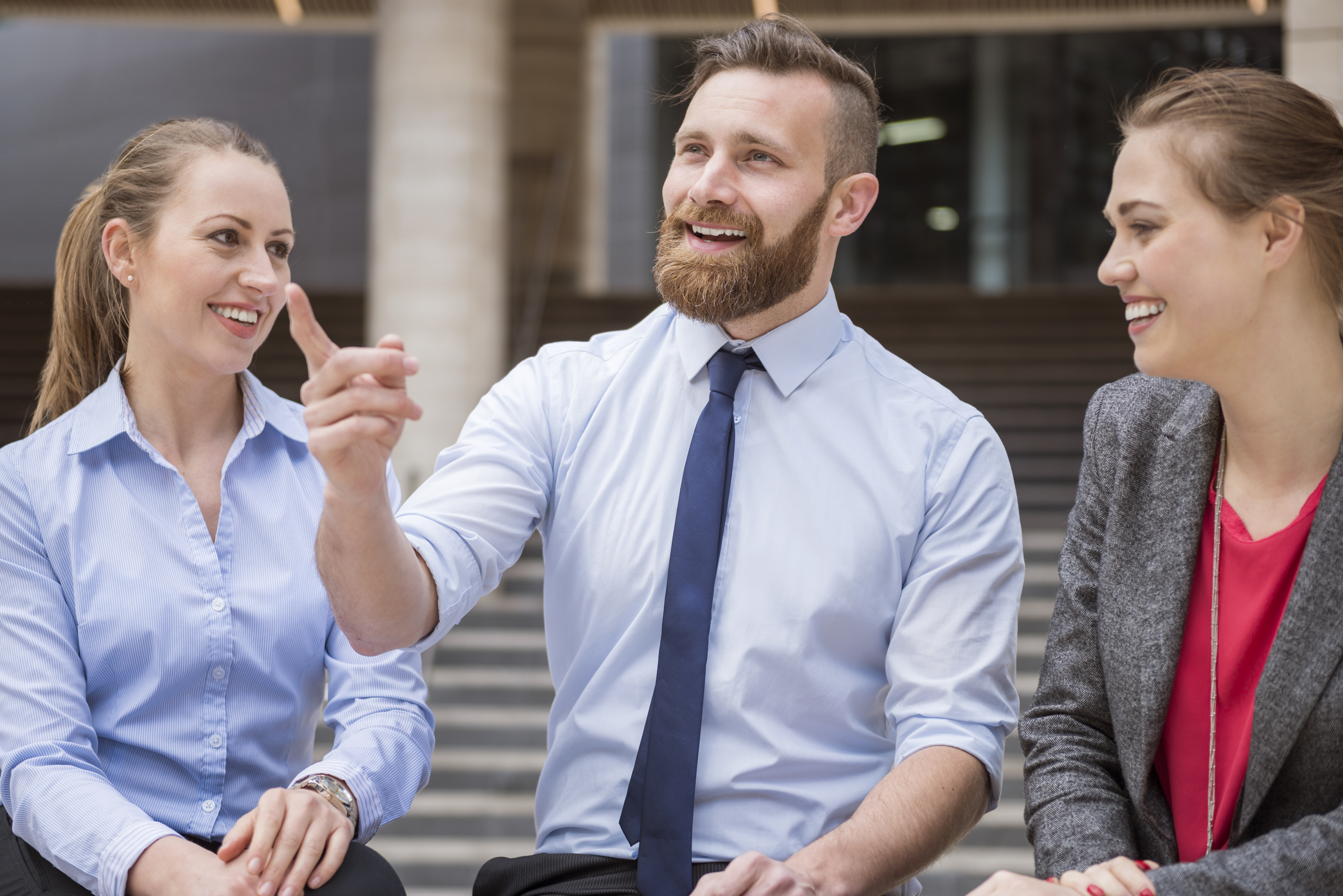 Three real estate agents sitting outside and chatting with each other