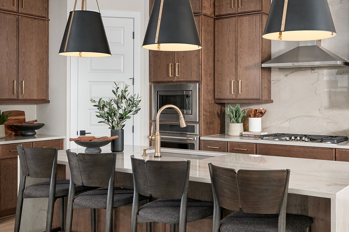 A kitchen with a generous island and elegant brown cabinetry