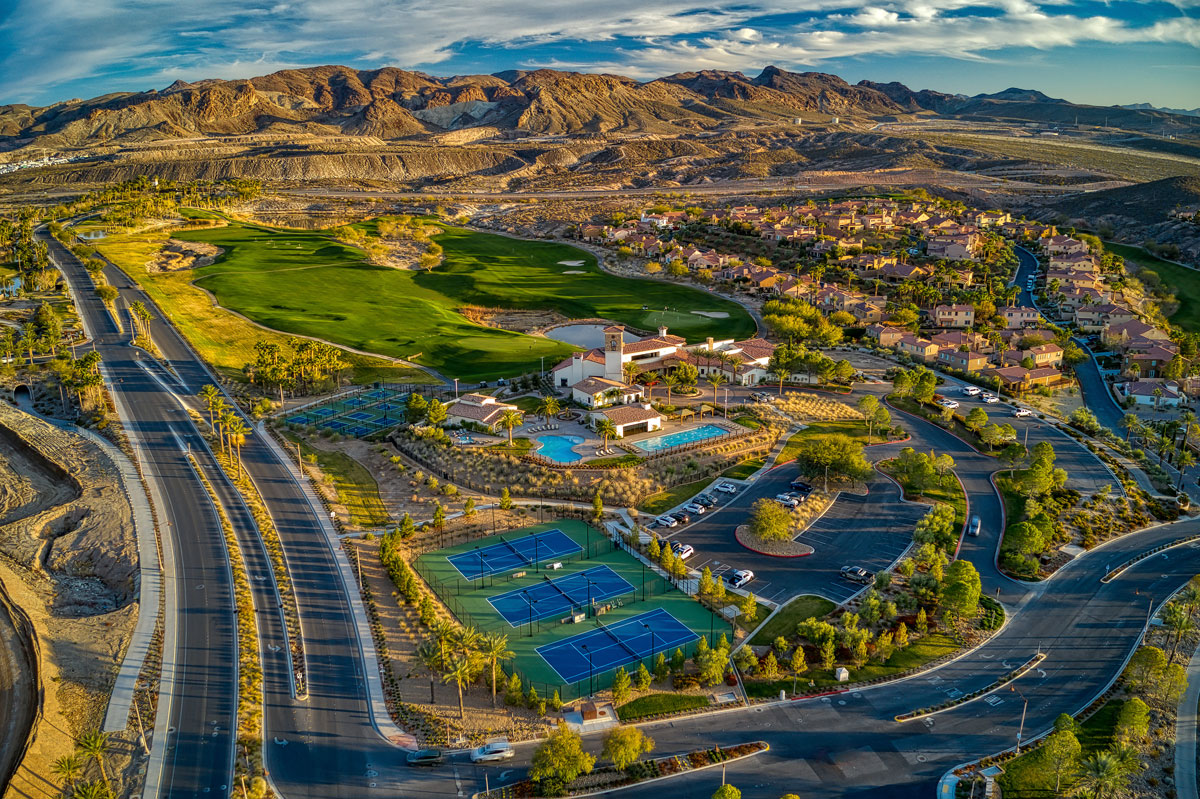 Aerial view of the The Salerno Summit at SouthShore Lake Lake Vegas golf course, tennis courts, pools, clubhouse, and the mountain backdrop