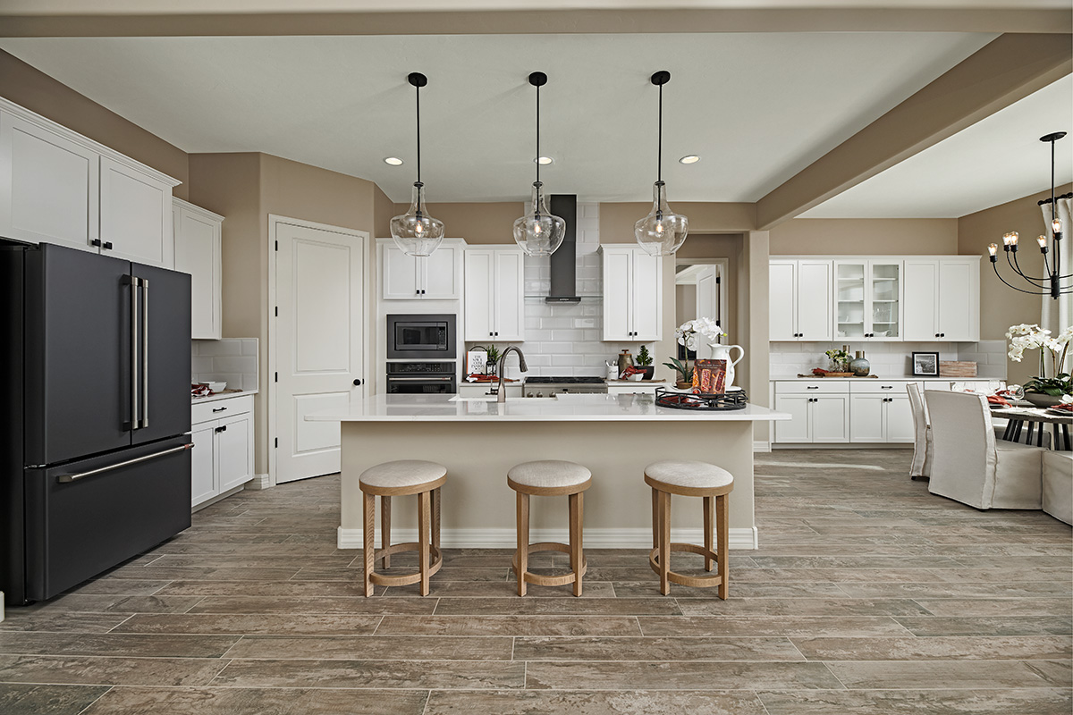 A kitchen with abundant white cabinetry, an island, and a walk-in pantry