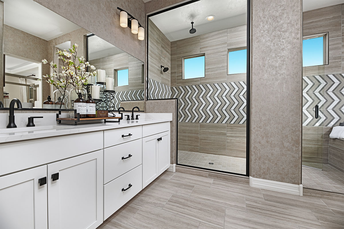 A lavish primary suite bathroom with double sinks and a walk-in shower