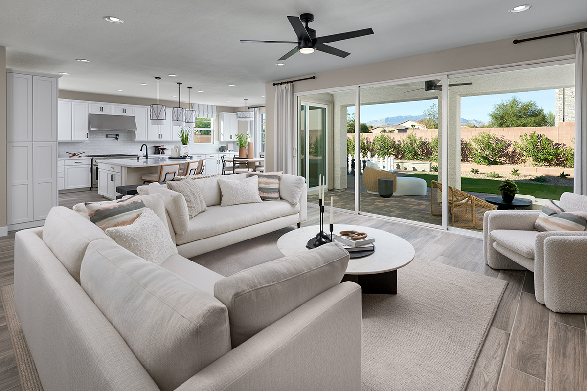 A generous great room with sliding glass patio doors and an adjacent kitchen