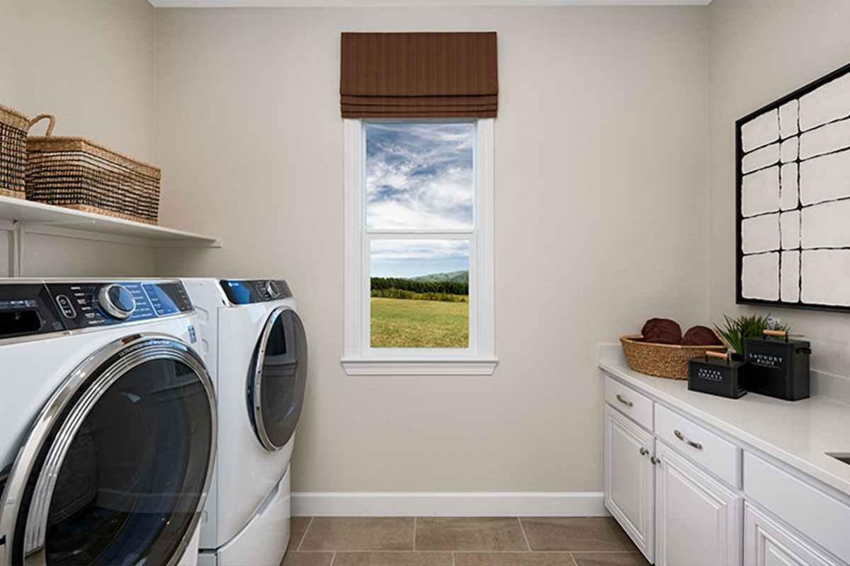 A convenient laundry with shelving and cabinets