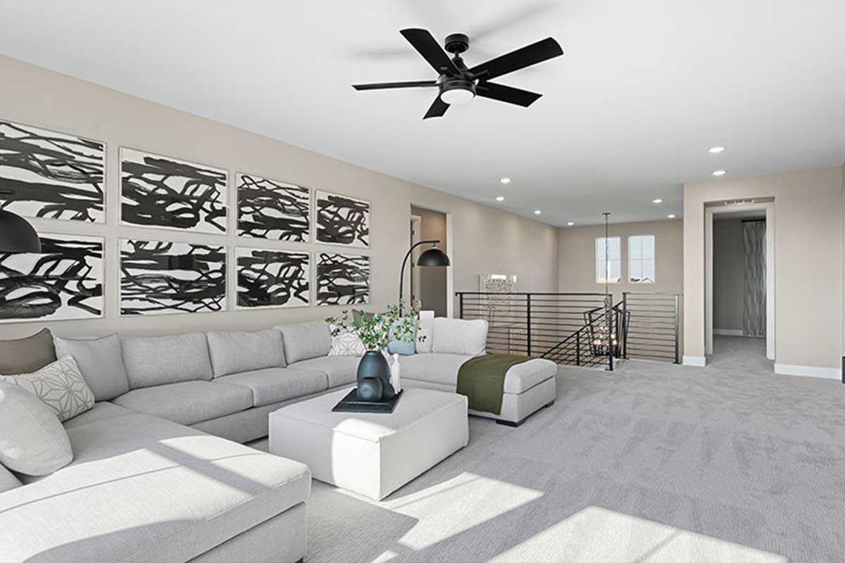 A loft with a large couch and ceiling fan