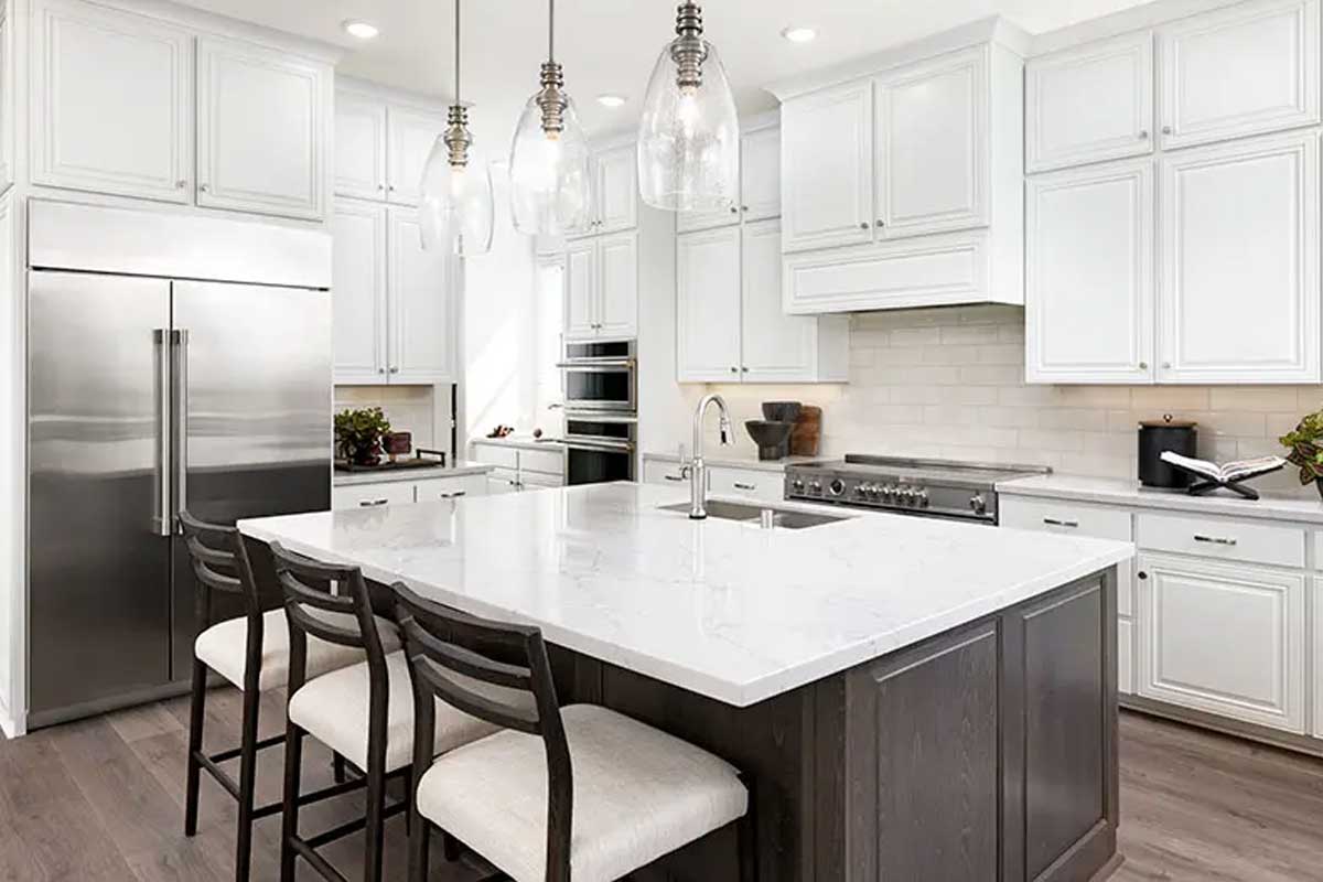 A beautiful kitchen with a large center island, stainless-steel appliances, and white cabinetry