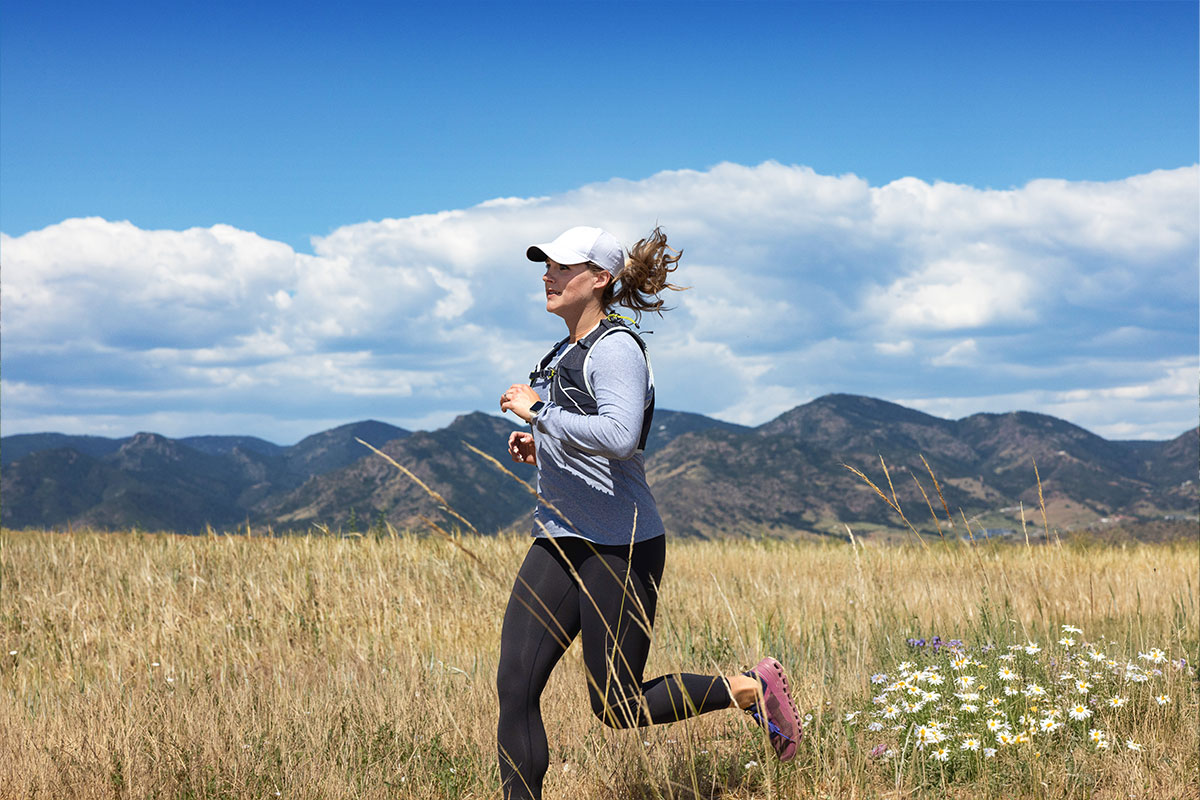 A woman running on one of the Sterling Ranch community trails, with mountains in the background