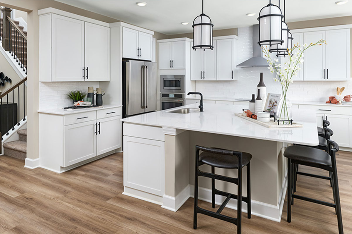 A Sage floor plan kitchen with white cabinetry and a large center island