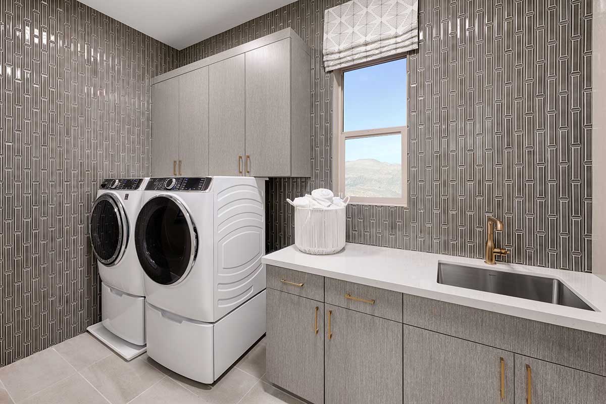 Lavish laundry room with a sink and cabinets