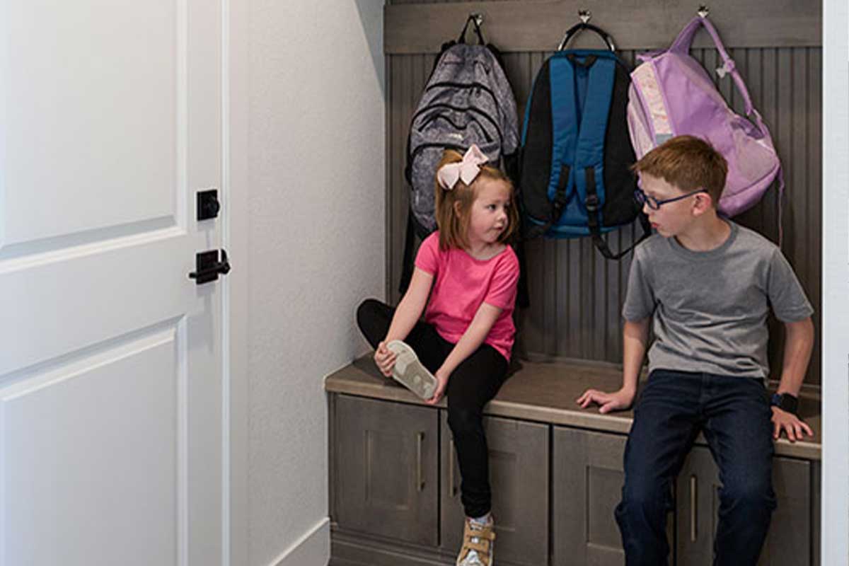 Young brother and sister in a mudroom