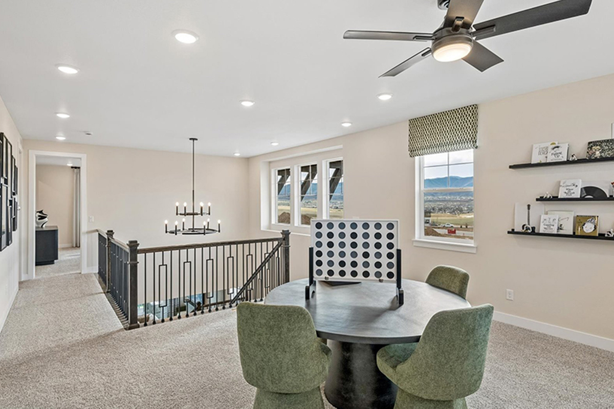 Loft with a ceiling fan in a new home