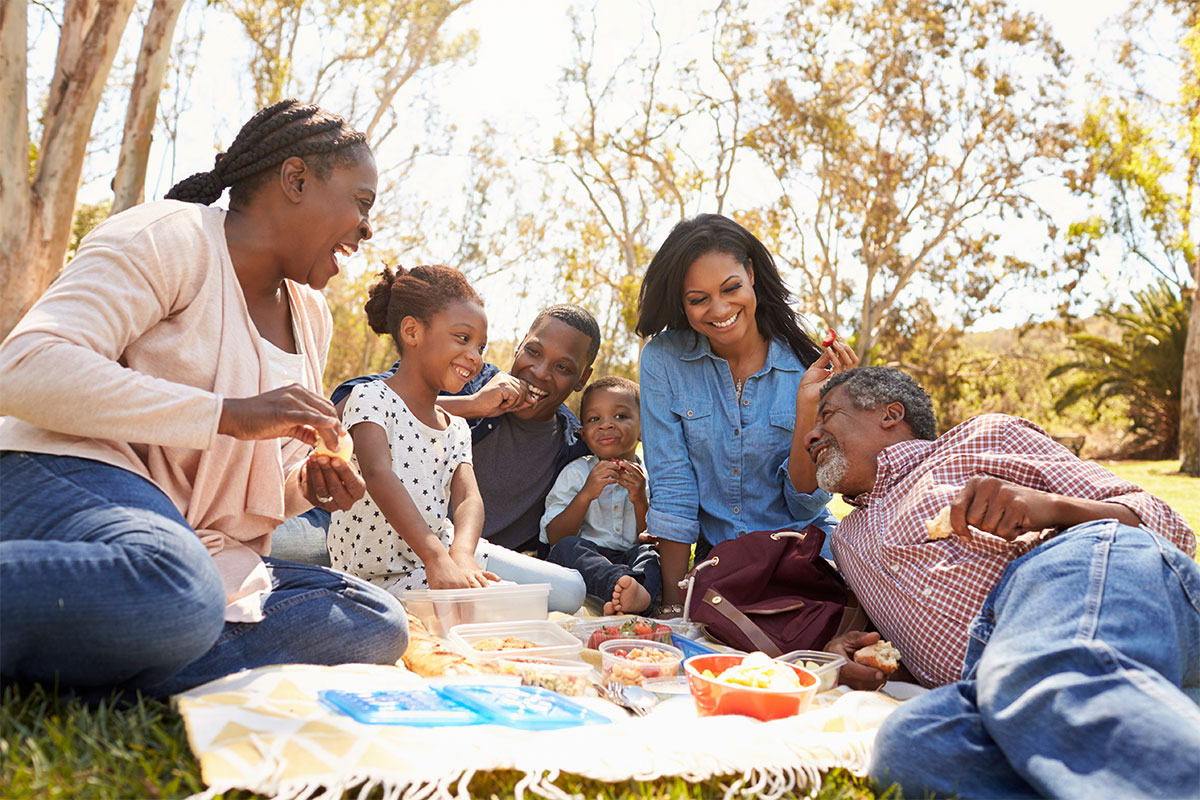 A happy multi-generational family having a picnic at a community park