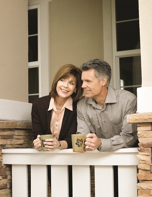 Retired couple standing on front porch
