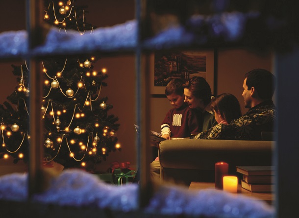 Family reading by Christmas tree