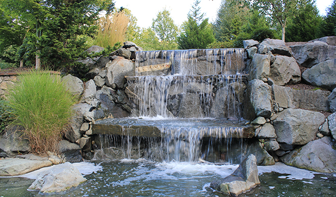 Rock waterfall with greenery in background