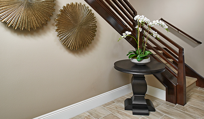 Whide orchid sitting on dark entry table next to stairs