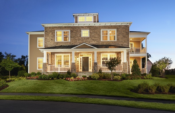 Exterior of elegant brick-front home with covered front and side porches, plus a balcony