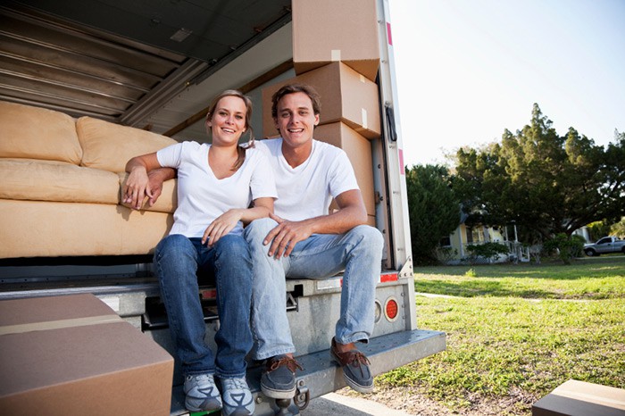 Couple sitting in the back of a moving truck