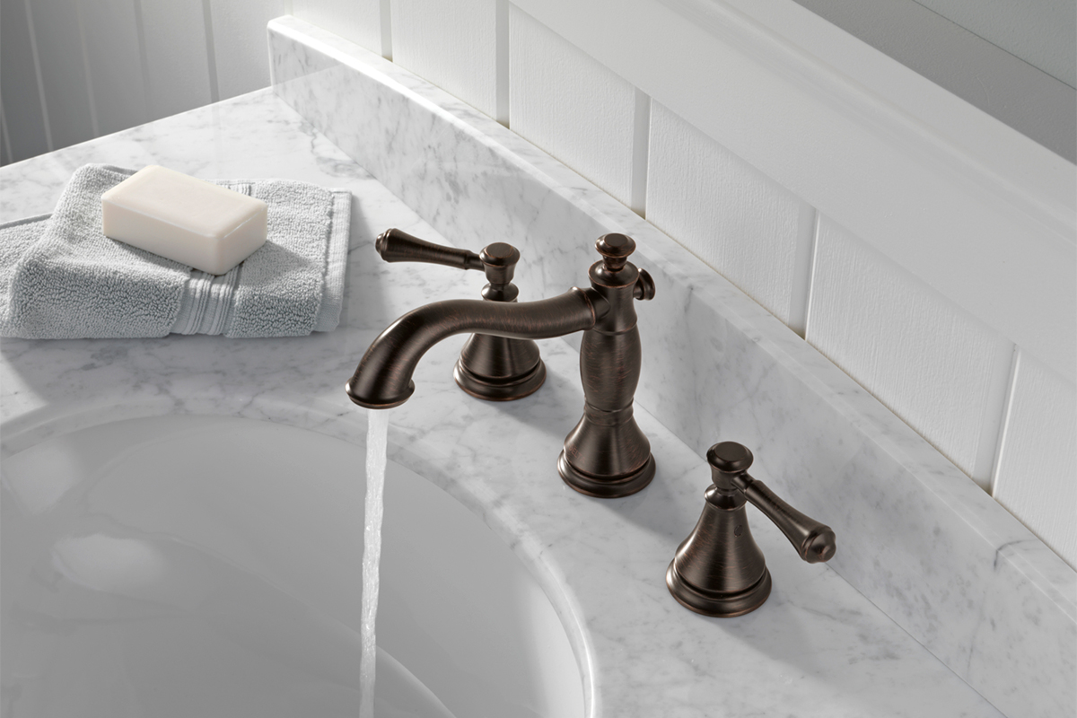 Bronze Delta faucet spraying water into sink