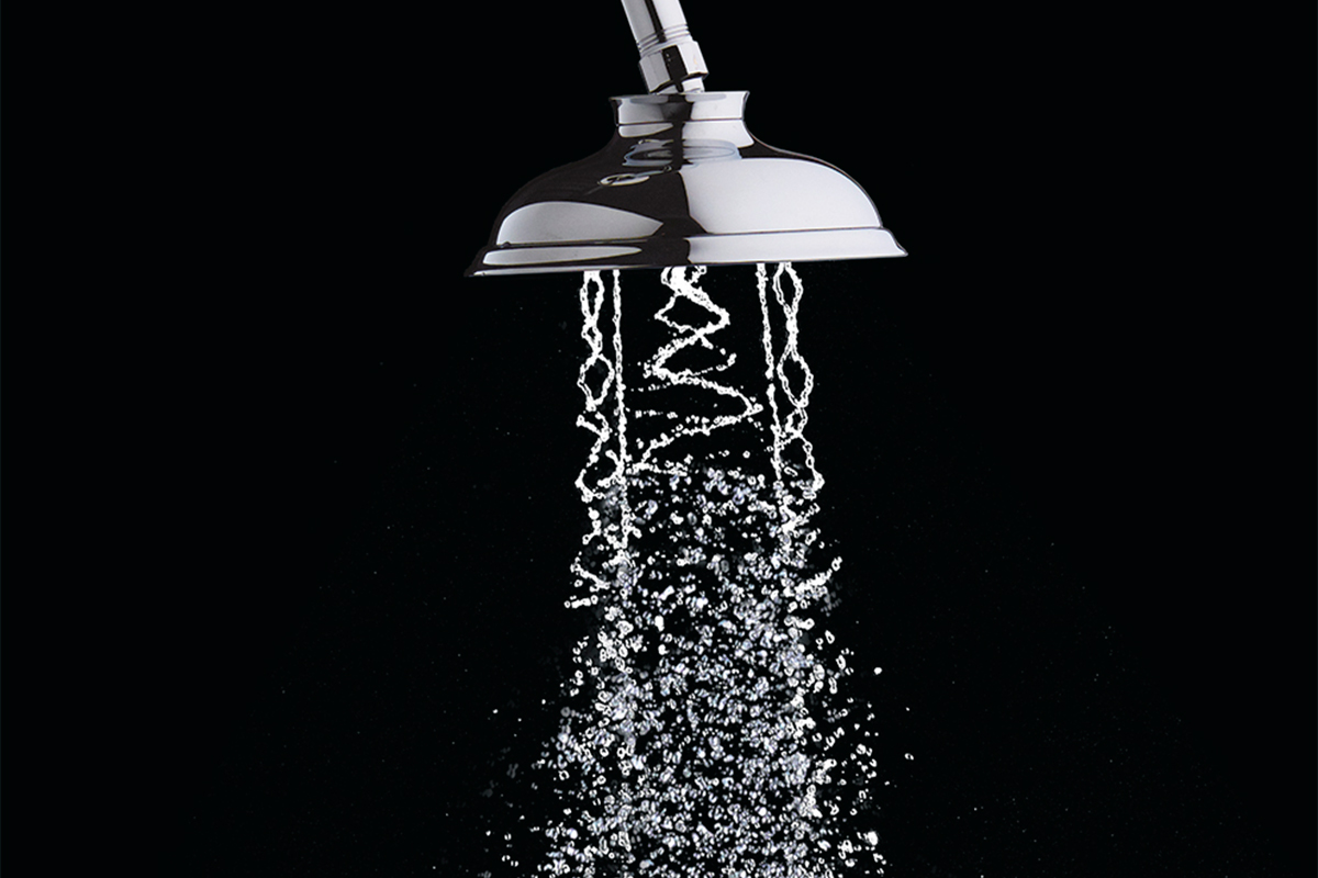 Showerhead spraying water over black background