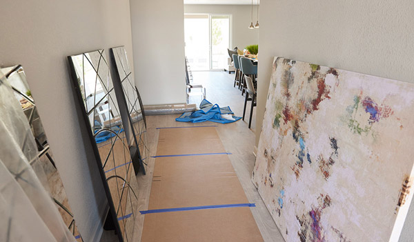 Art work leaning against walls, ready to be hung in model home