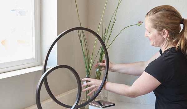 Woman putting plants in vases in model home