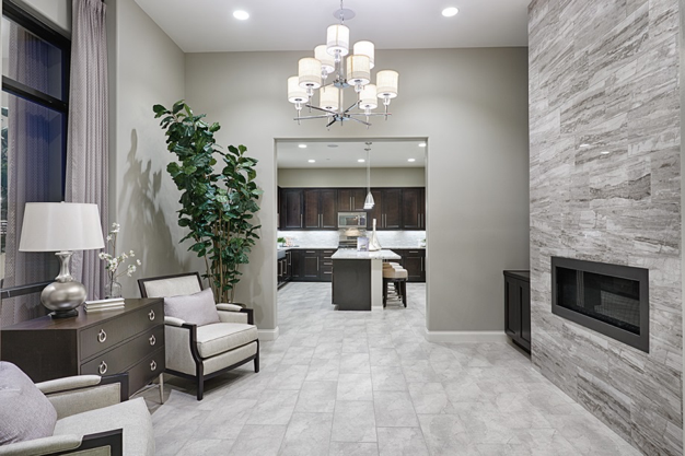 Room with tile flooring, a marble-look, porcelain tile fireplace and a chandelier