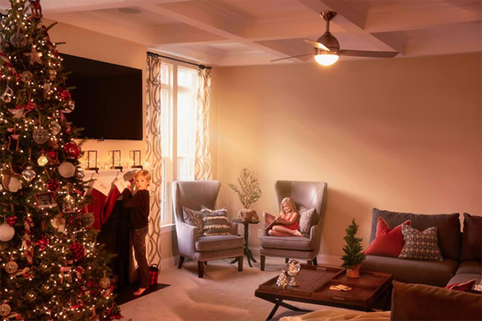 Children in family room with fireplace and tree