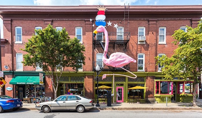 Front of brick building with shops and tall flamingo statue